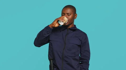 Security agent uses coffee cup to remain energized while securing post Stock Footage 278068698