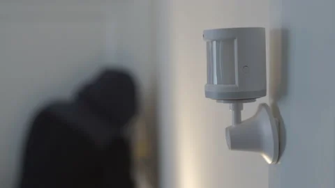 Security alarm motion sensor on the wall of the house, wireless motion detector Stock Footage 168876162