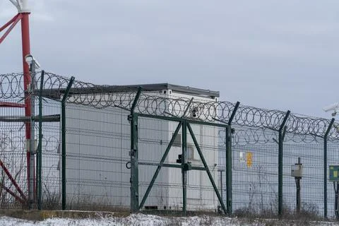 Security building with barbed wire in a remote location during winter Stock Photos