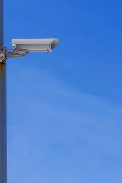Security camera against the blue sky are monitoring. Stock Photos