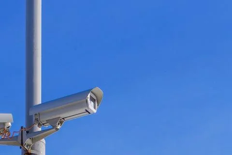 Security camera against the blue sky are monitoring. Stock Photos