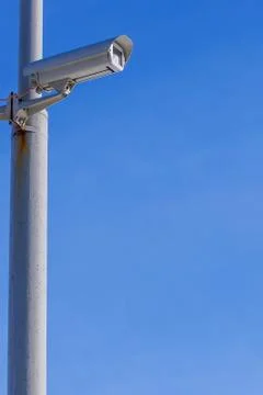 Security camera against the blue sky are monitoring. Stock Photos