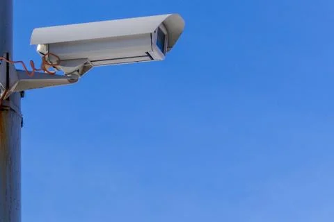 Security camera against the blue sky are monitoring. Stock Photos