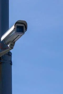 Security camera against the blue sky are monitoring. Stock Photos