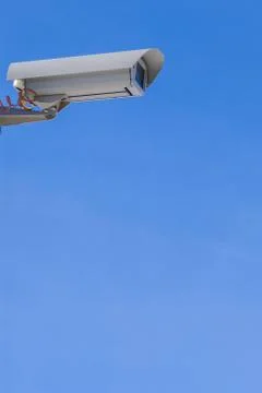 Security camera against the blue sky are monitoring. Stock Photos