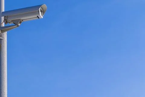 Security camera against the blue sky are monitoring. Stock Photos