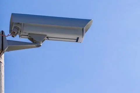 Security camera against the blue sky are monitoring. Stock Photos