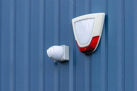 Security camera and alarm box on blue metal wall Stock Photos