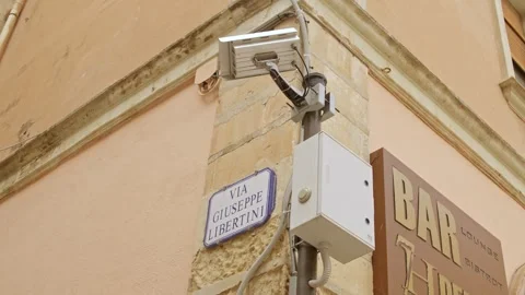 Security camera and Via Giuseppe Libertini street sign in historic Lecce Italy Stock Footage 336760706