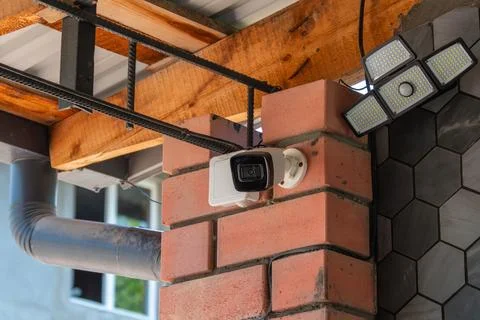 Security Camera and Motion Sensor Light on Brick Pillar 库存照片