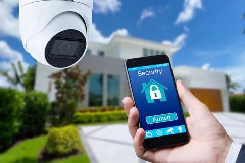 Security camera and smart home app, private house on the background. Stock Photos