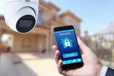 Security camera and smart home app, private house on the background. Stock Photos