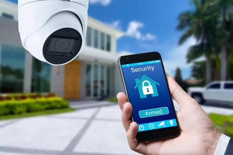 Security camera and smart home app, private house on the background. Stock Photos