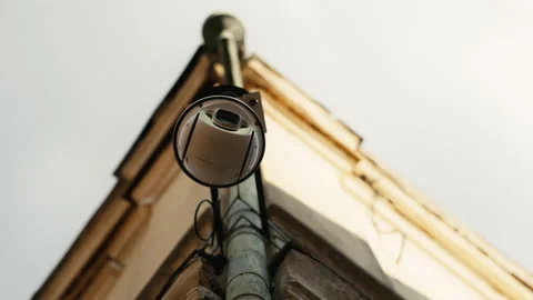 A security camera is attached to a buildings side Stock Footage 275207022