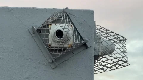 A security camera in a cage hangs to a wall in a suburban part of Cape Town Stock Footage 331230757