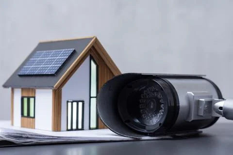 Security camera CCTV with miniature smart home model featuring solar panels.  Stock Photos