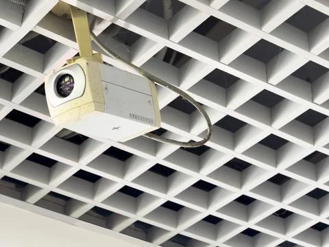 A security camera on the ceiling follows every step of a person Stock Photos