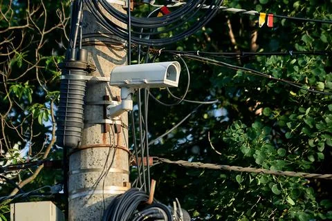 A security camera is hanging on a concrete post Stock Illustration