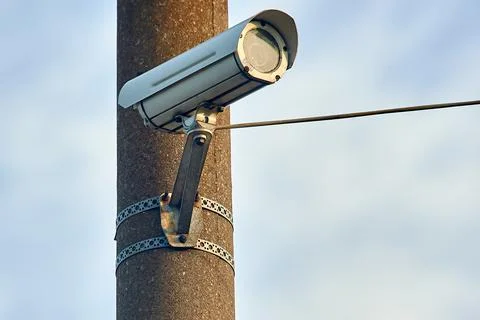 A security camera is hanging on a concrete post Stock Illustration