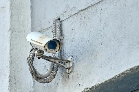 A security camera is hanging on a concrete post Stock Photos