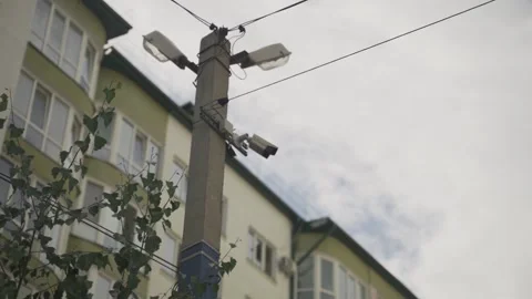 Security camera hanging on the utility pole in the yard of the apartment block Stock Footage 149128005
