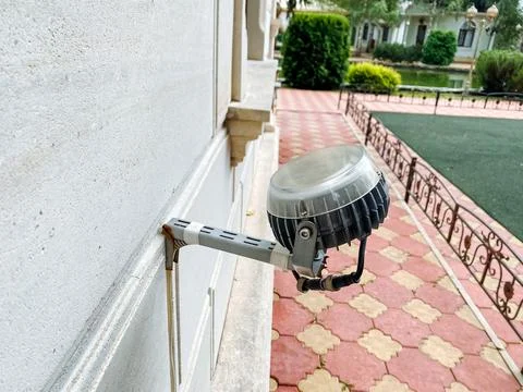 A security camera has been carefully mounted to the side of a building, ens.. Stock Photos