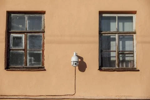 Security camera on the house. two windows and video surveillance on the wall of Stock Photos