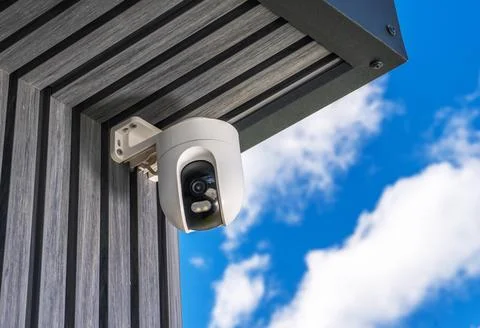 Security camera installation on building under blue sky with clouds Foto stock