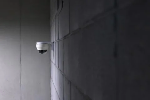 A security camera installed on a concrete wall. Foto stock
