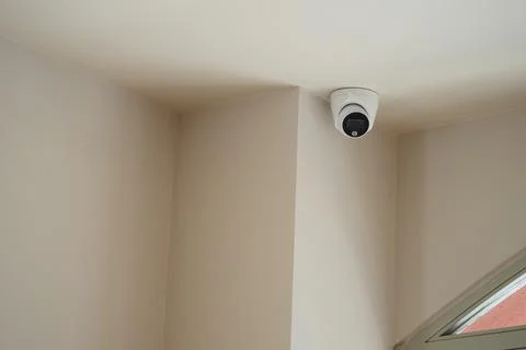 Security camera installed in a corner of a simple indoor space Photos