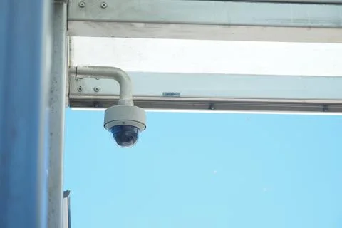Security camera monitors clear blue sky above Stock Photos