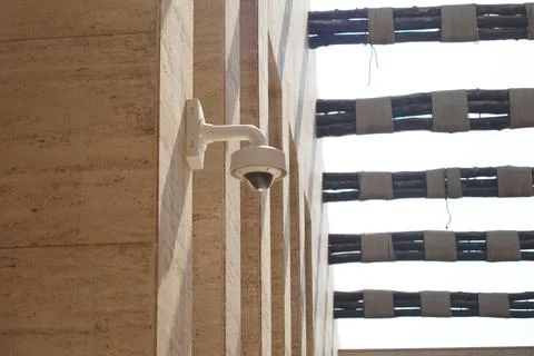 Security camera mounted on building in bright sunlight Foto stock