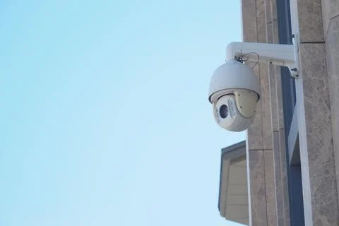 Security camera mounted on a building during the day Stock Photos