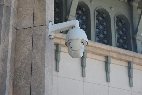 Security camera mounted on building exterior observing the surroundings Stock Photos