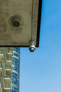 Security camera mounted on building in sunny city Stockfoto's