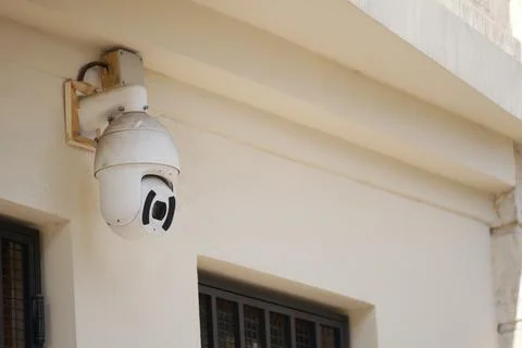 Security camera mounted on building wall near entrance Stock Photos