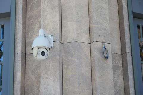 Security camera mounted on building wall in urban area Stock Photos