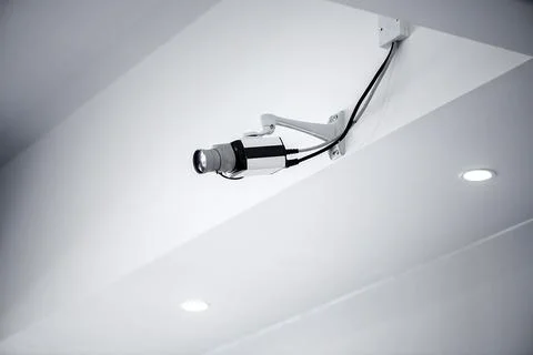 Security camera mounted on ceiling in modern interior Stockfoto's