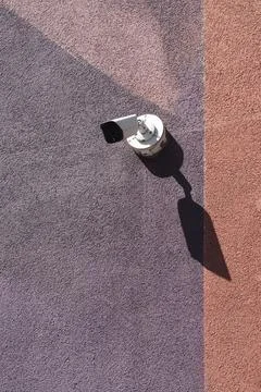 Security Camera Mounted on Colorful Plaster Wall Exterior Stock Photos