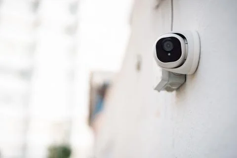 Security camera mounted on exterior wall of residential building, modern ho.. Stock Photos