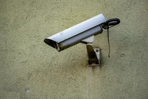 Security Camera Mounted on a Green Wall monitoring state surveillance security Stock Photos