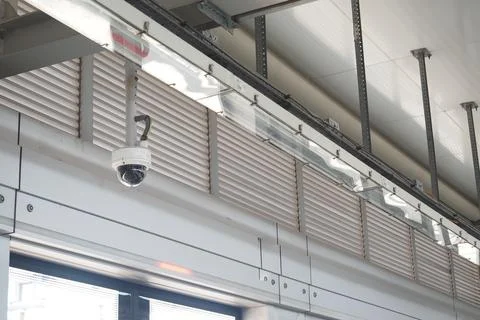 Security camera mounted on industrial ceiling in a modern building Stock Photos