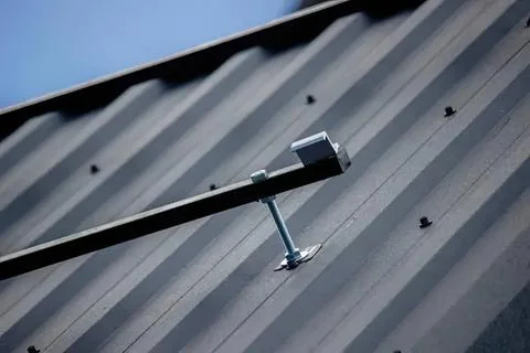 Security camera mounted on metal building wall outdoors Stock Photos