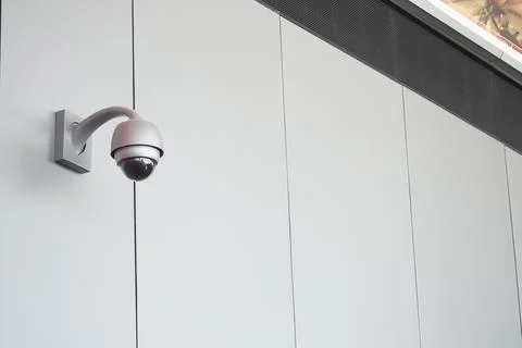 Security camera mounted on a wall in a public space Stock Photos