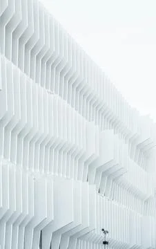 A security camera near parallel white ribs in a building facade in Madrid. Stock Illustration