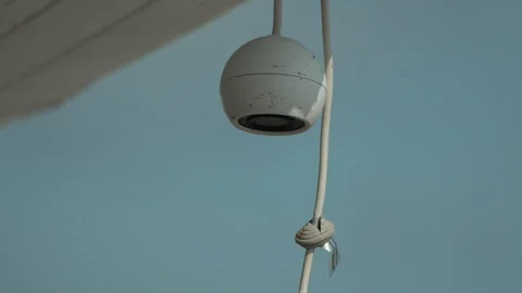 Security camera, outdoor, surveillance, white device mounted on building, cable Stock Footage 321866803