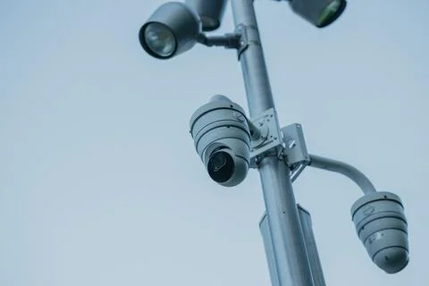 Security camera on pole against clear sky. CCTV video surveillance system mon Stock Photos
