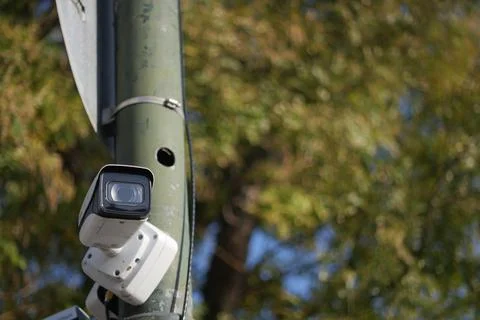 Security camera on a pole in a public area during daytime Stock Photos