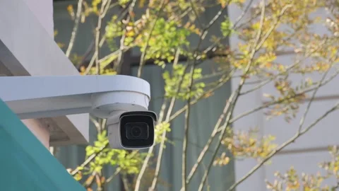 Security camera providing surveillance on a sunny day with green trees in b.. Stock Footage 333029851