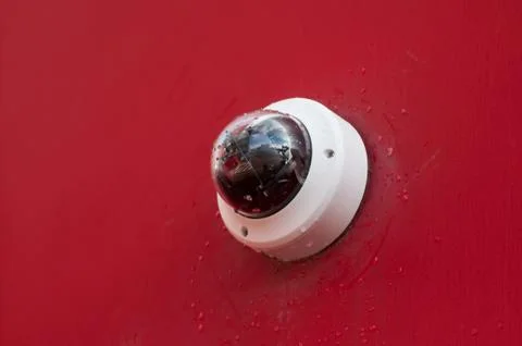 Security camera on red wall background Stock Photos